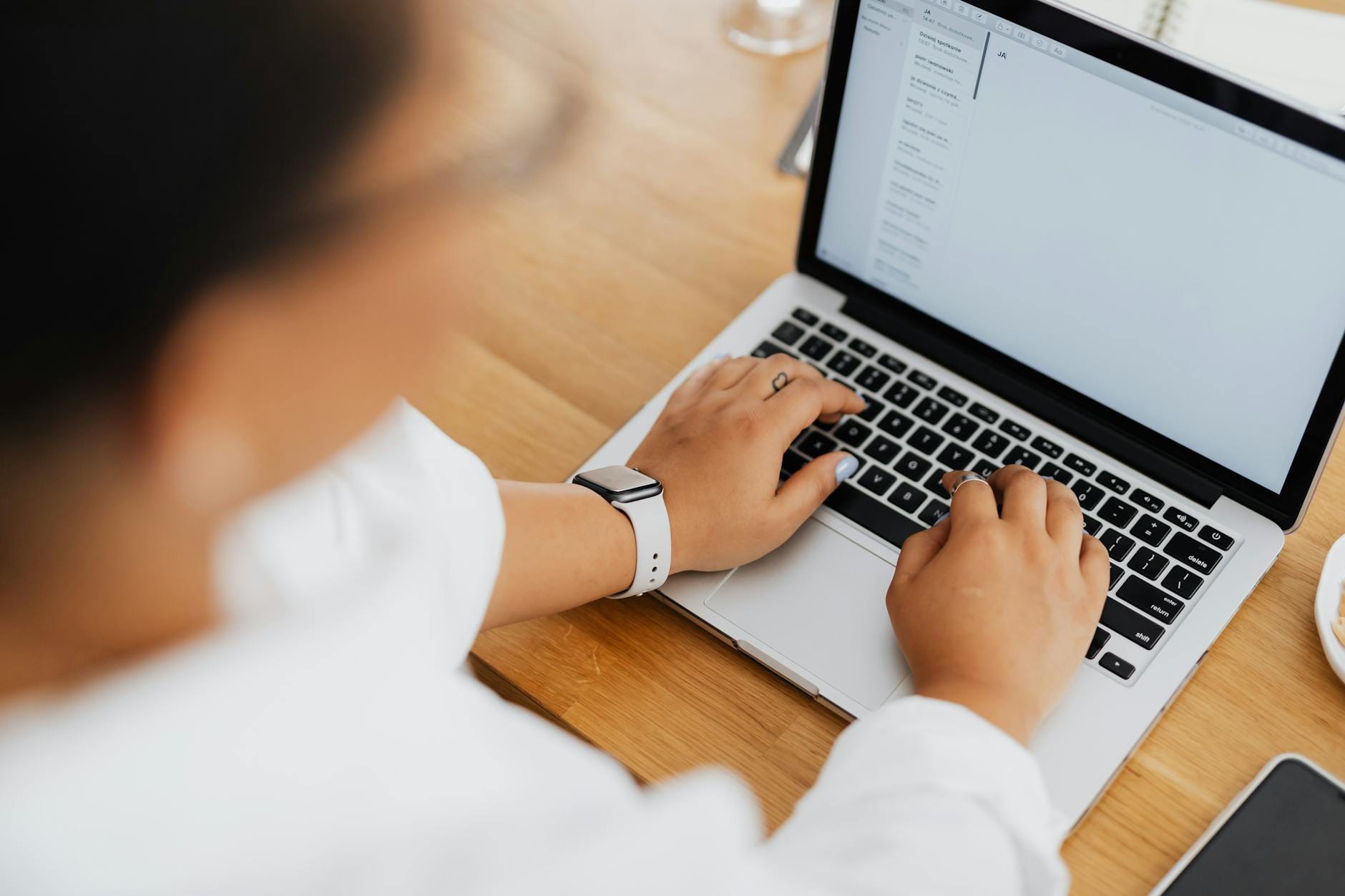 Hands typing on laptop keyboard setting up professional email hosting