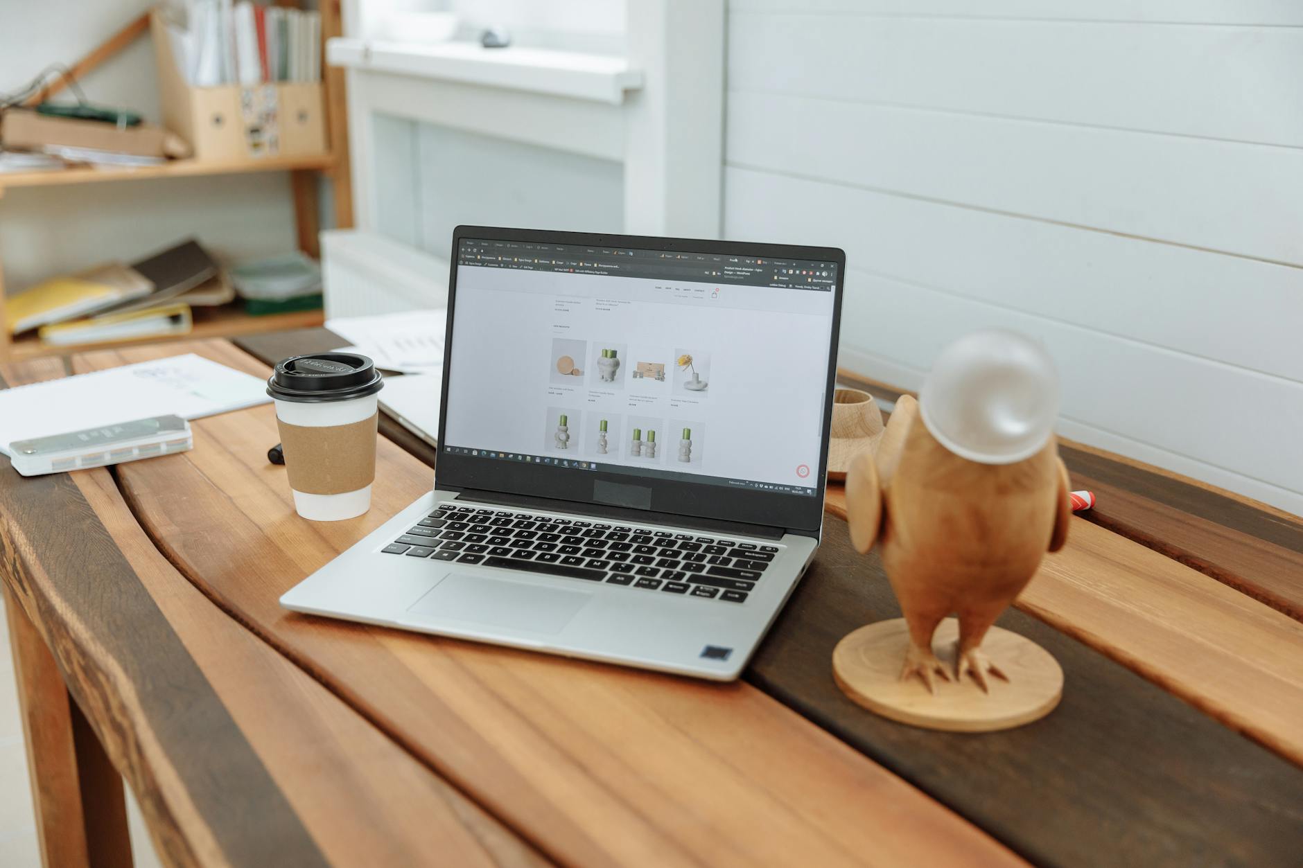 Small business owner working on website from office desk with laptop
