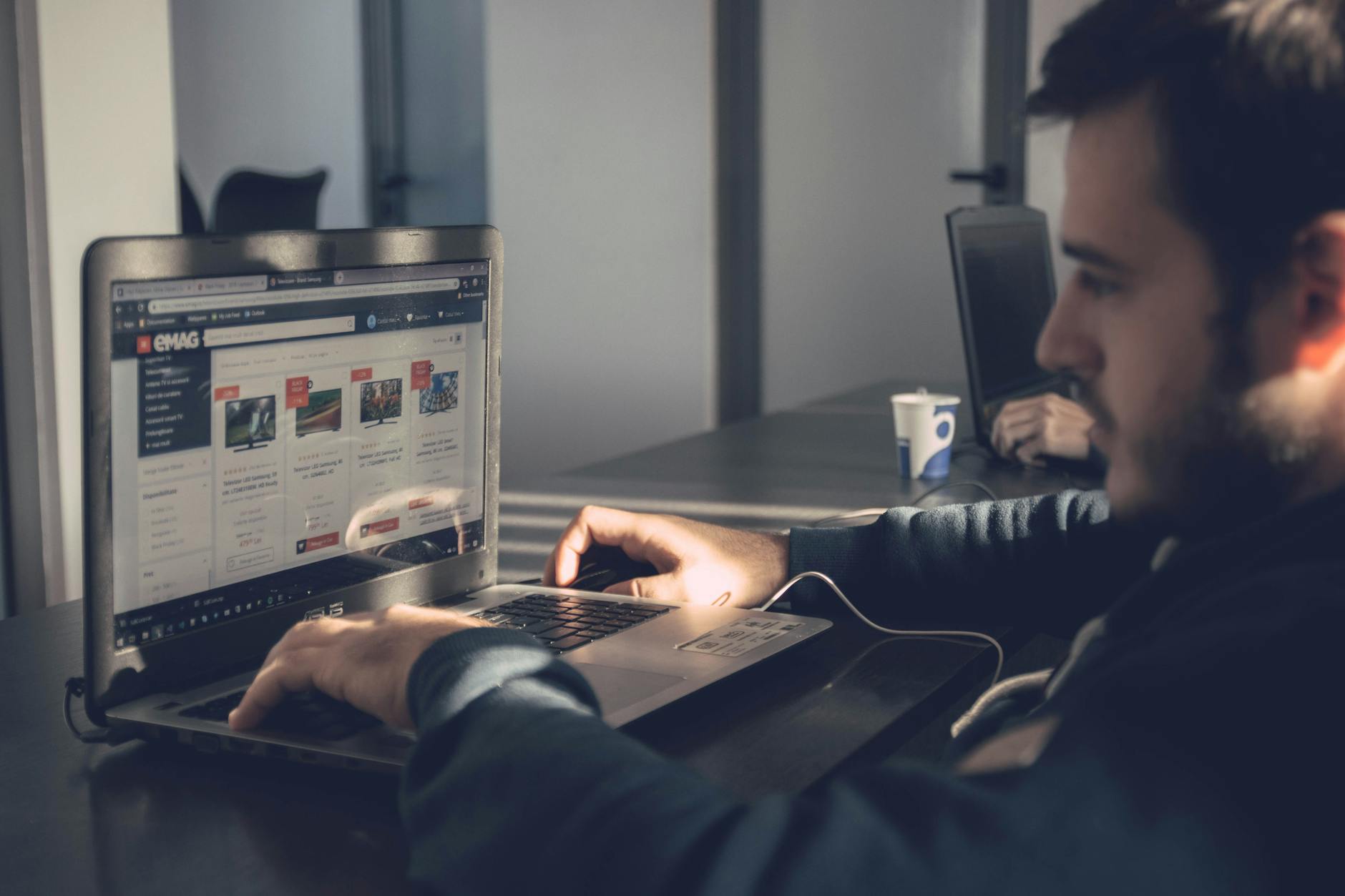 Entrepreneur reviewing business website hosting options on laptop