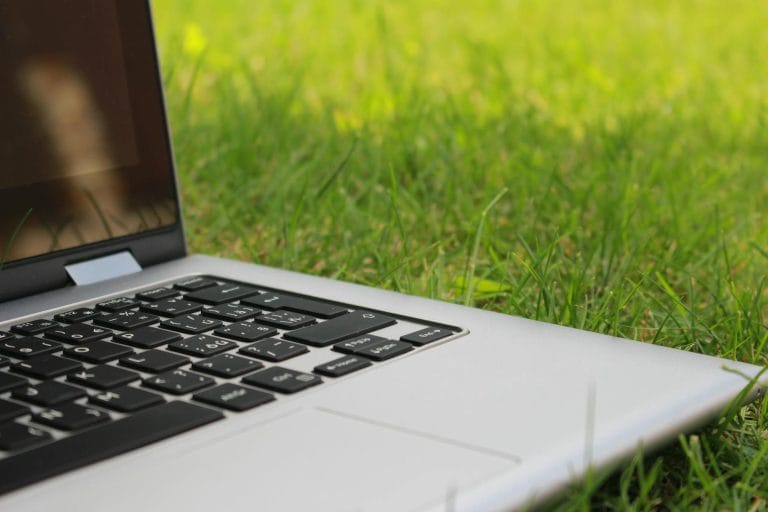 Best Cheap Web Hosting for Students in 2026 (From $1.95/Month) - Silver laptop computer on vibrant green grass depicting remo