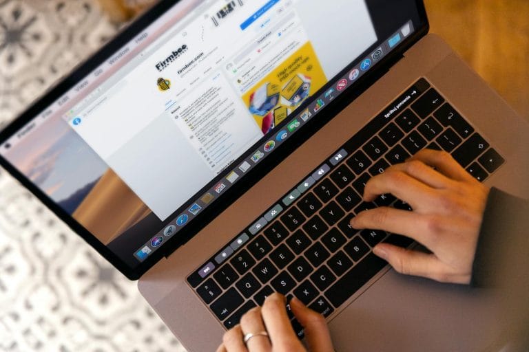 Best Email Hosting Services in 2026: 6 Providers Compared - Hands typing on a laptop at a desk, engaging in online work, and