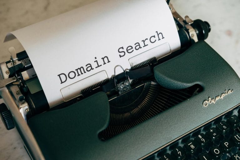 How to Choose a Domain Name for Your Website (2026 Guide) - Close-up of a vintage typewriter with paper displaying 'Domain Se