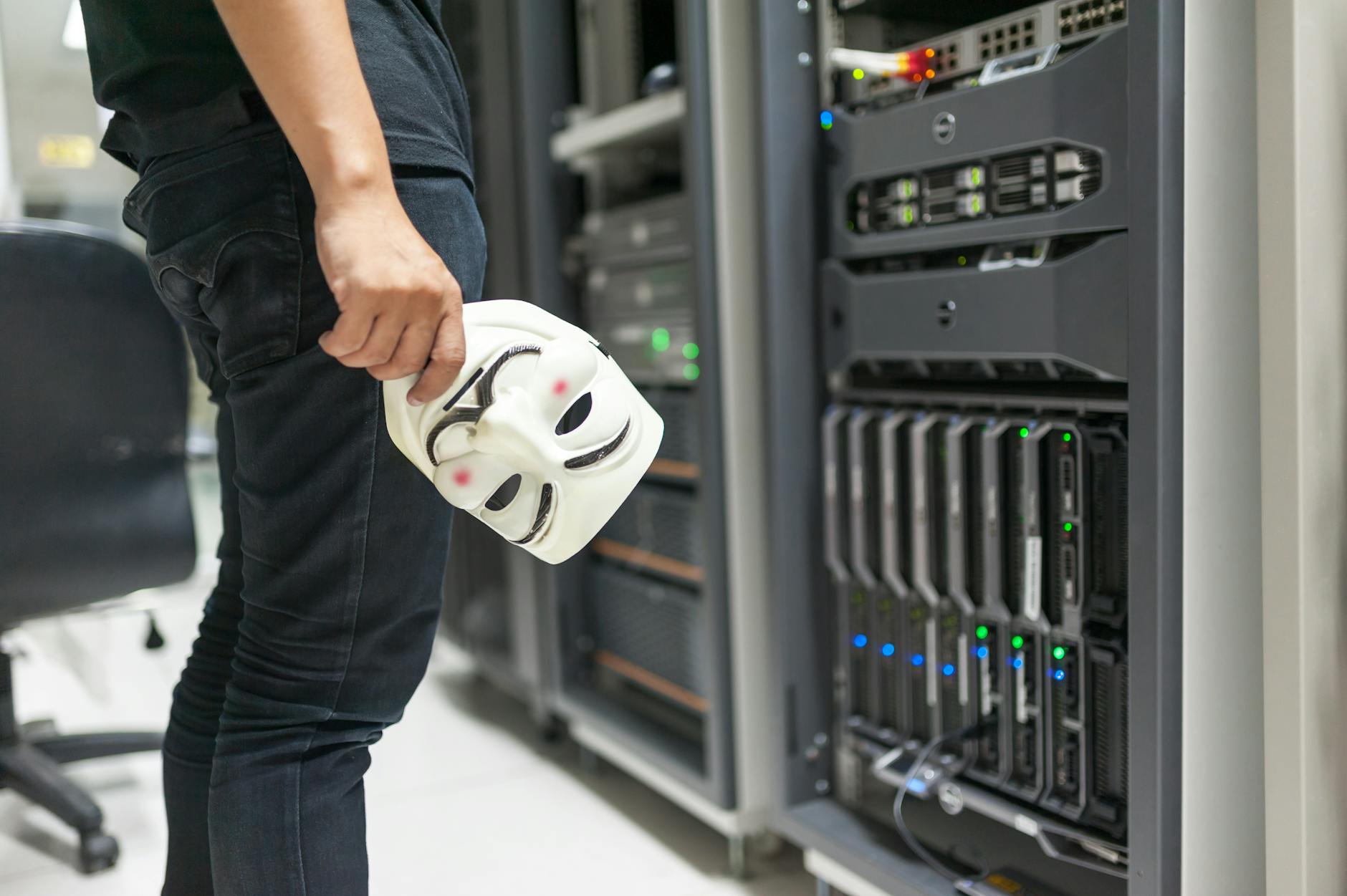 Shared Hosting vs Cloud Hosting: Which One Should You Pick in 2026? - Person holding anonymous mask near servers, hinting at