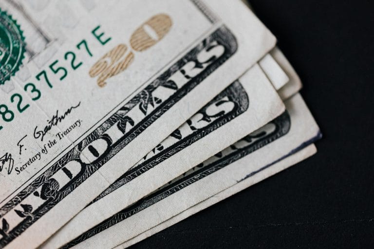 A detailed view of American dollar bills in a close-up shot on a black background, symbolizing finance.