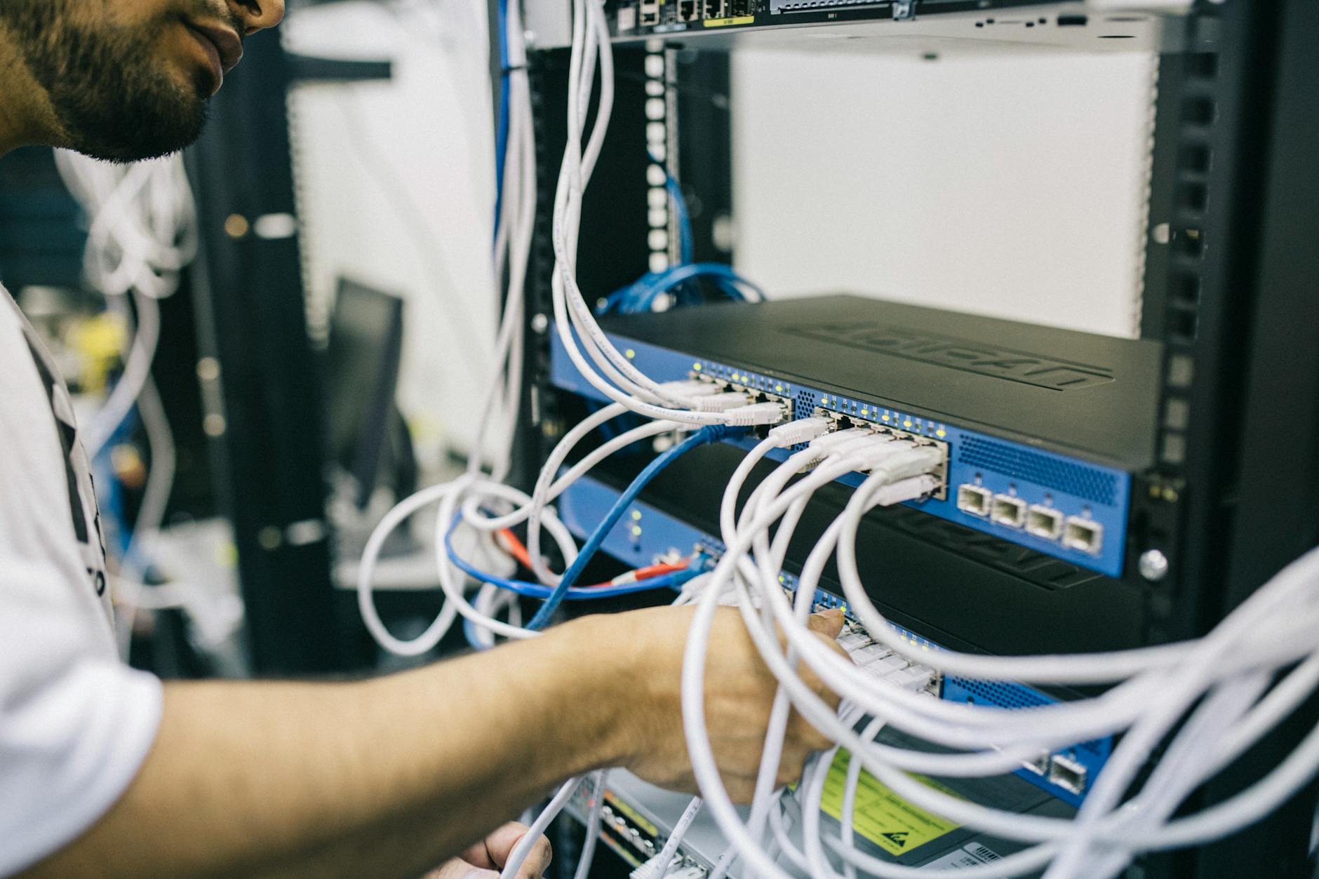 What Is Managed WordPress Hosting and Is It Worth Paying Extra? - An IT professional configuring network cables in a server r